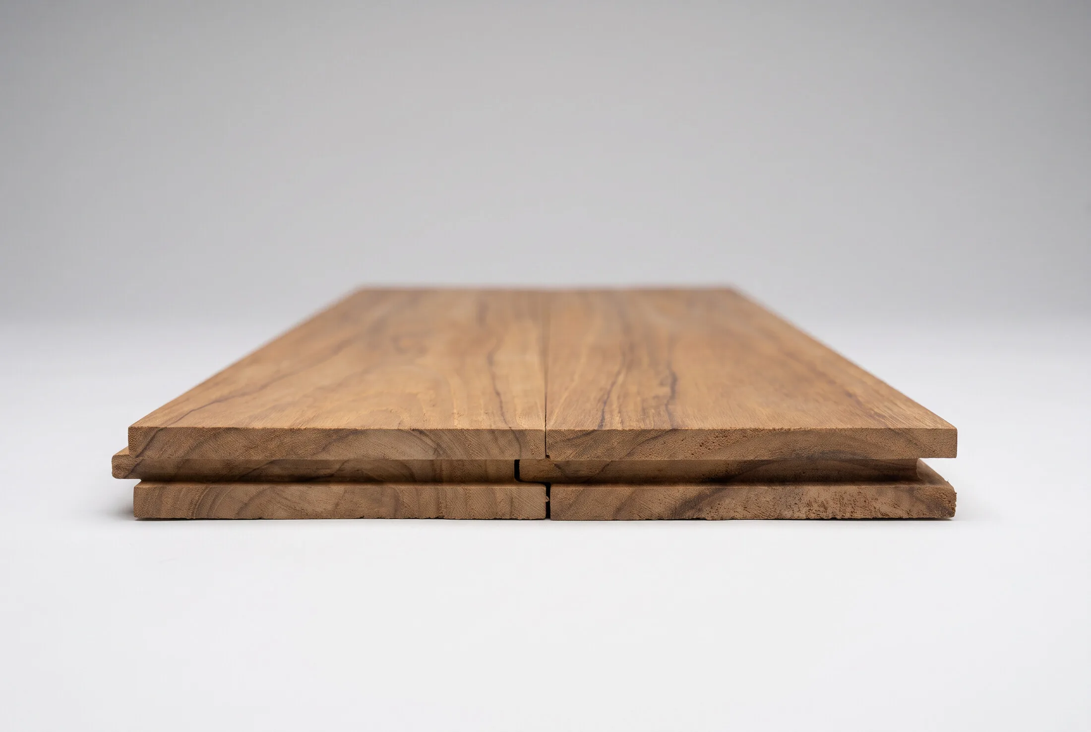 Two solid teak boards interlocked, tongue-and-groove profile