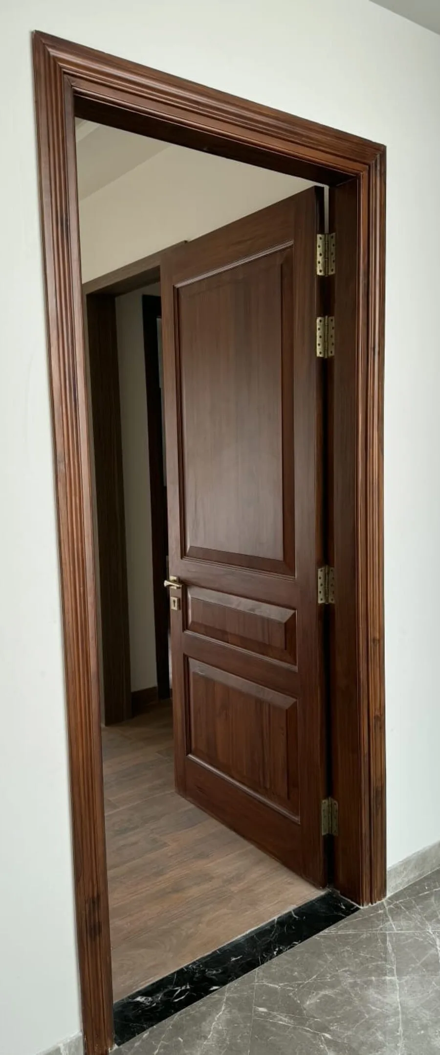 Solid teak door frame with a panelled door